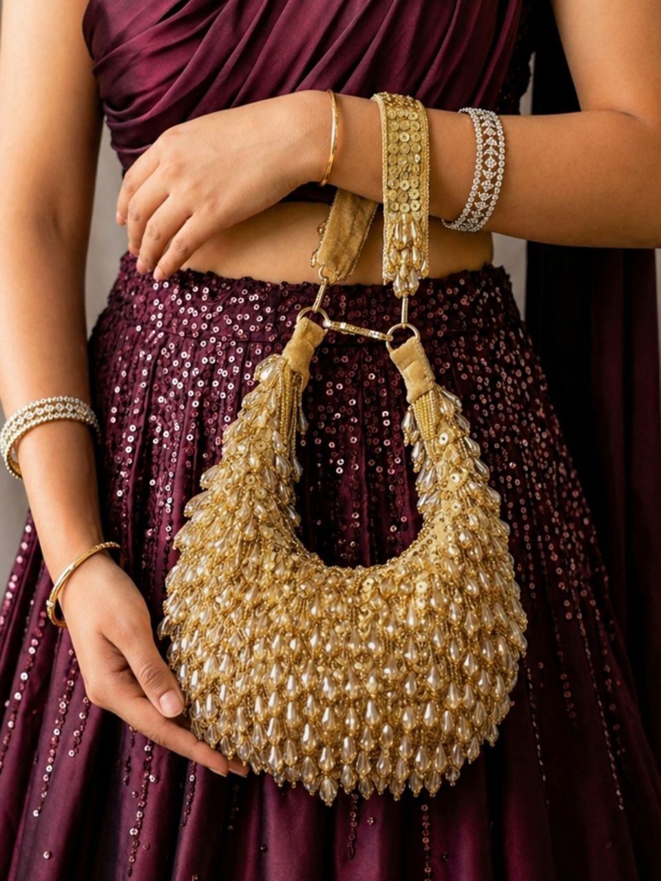 Aabha gold pearl beaded crescent clutch styled with handle