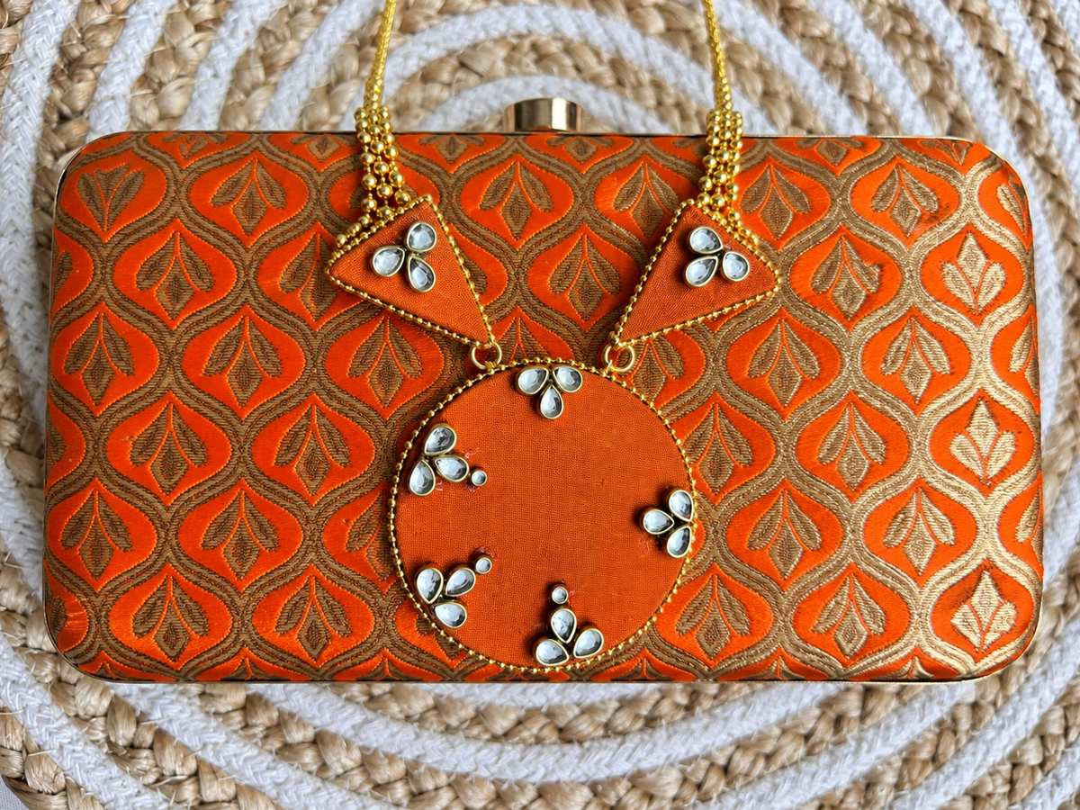 The Rust Edit orange brocade clutch with coordinated interchangeable pendant jewellery set